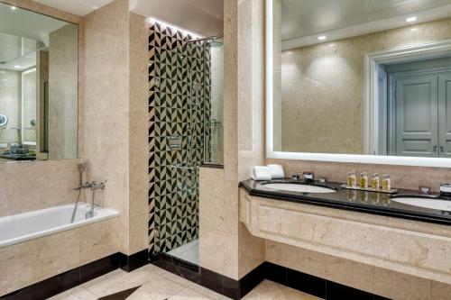 a bathroom with two sinks and a tub and a mirror at Hilton Molino Stucky Venice in Venice