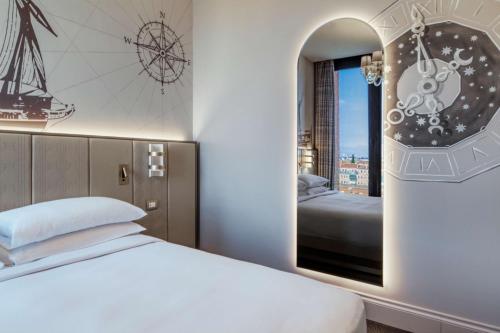 a bedroom with a bed and a window at Hilton Molino Stucky Venice in Venice