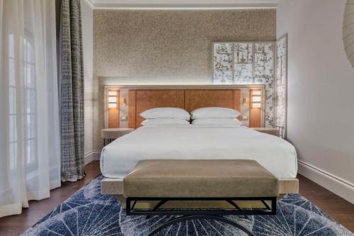 a bedroom with a large white bed with a wooden headboard at Hilton Molino Stucky Venice in Venice