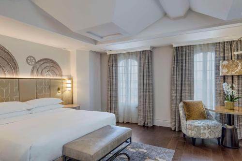 a bedroom with a bed and a desk and a chair at Hilton Molino Stucky Venice in Venice