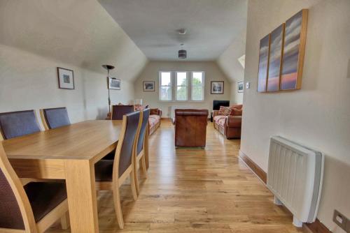 a dining room and living room with a table and chairs at 1 Argyle Place, Dornoch in Dornoch