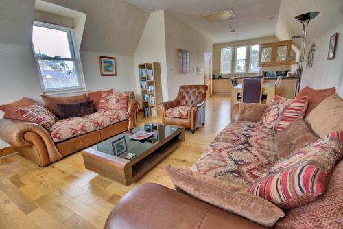 a living room with couches and a table at 1 Argyle Place, Dornoch in Dornoch