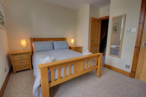 a bedroom with a wooden bed with two night stands and two lamps at 1 Argyle Place, Dornoch in Dornoch