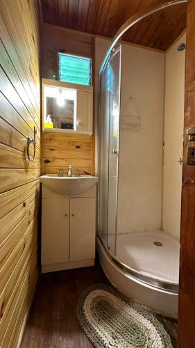a bathroom with a shower and a sink and a tub at Cabañas Iremía in Uribelarrea