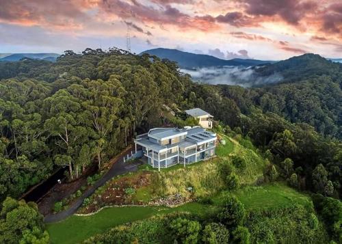 an aerial view of a house on a hill in the forest at ON TOP Of THE WORLD Garden Studio in Kororo Basin