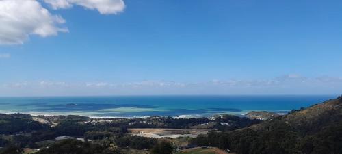a view of the ocean from the top of a mountain at ON TOP Of THE WORLD Garden Studio in Kororo Basin