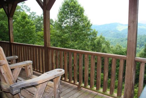 a rocking chair on a porch with a view of the mountains at Cliffside by Leatherwood Mountains Resort in Ferguson