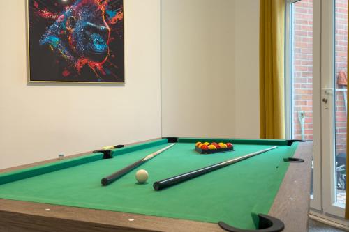 a room with a pool table with balls and bats at Amorly House - Sleeps 8 Free Permit Parking Big Spacious With Games Room in Norwich