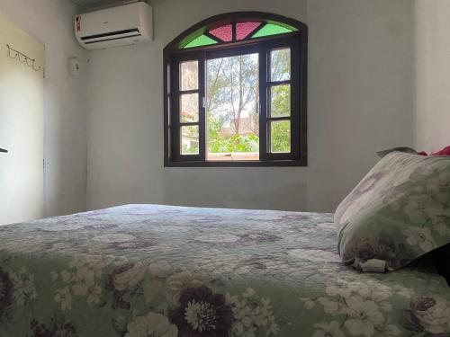 una camera da letto con un letto e una finestra di Cantinho da Pinheira a Palhoça