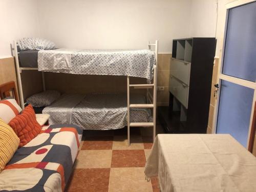a dorm room with two bunk beds and a tv at Estudio amueblado en El Ejido in El Ejido