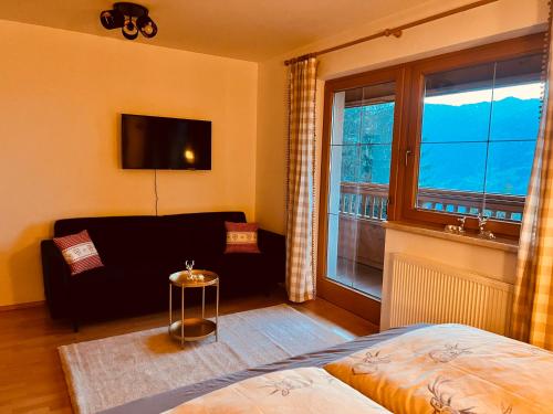 a living room with a couch and a window at New Chalet Platzhirsch Panorama Blick Sauna Rohrberg Maximilian in Rohrberg