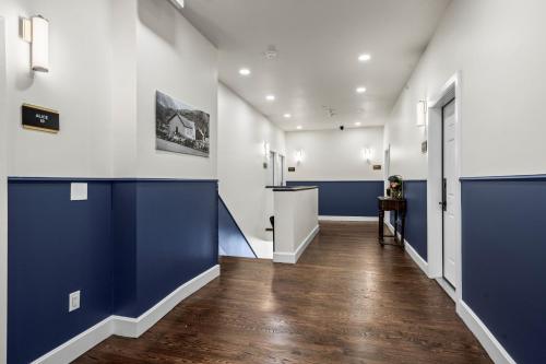 a hallway with blue and white walls and wooden floors at Club Hotel in Idaho Springs