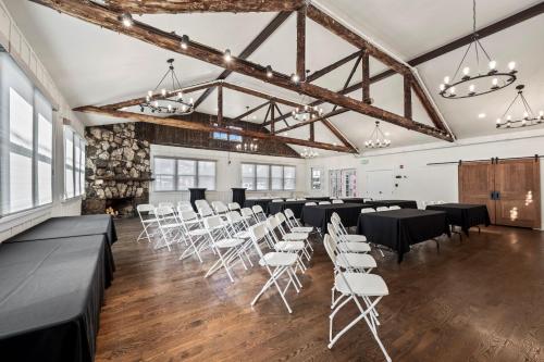 a banquet hall with black tables and white chairs at Club Hotel in Idaho Springs
