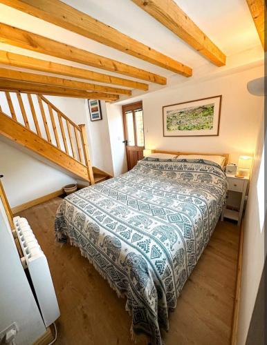 a bedroom with a bed and a wooden staircase at Loft cottage in Bonsall