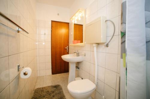 een witte badkamer met een toilet en een wastafel bij Apartments Petri in Tisno