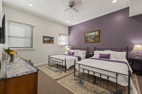 two beds in a room with purple walls at Club Hotel in Idaho Springs