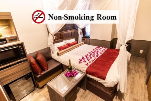 a room with aoir smoking room with a bed and a couch at BaliAn Resort Forest Ikebukuro in Tokyo