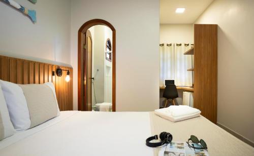 a bedroom with a bed with shoes on it at Pousada Timoneiro in Vila Velha