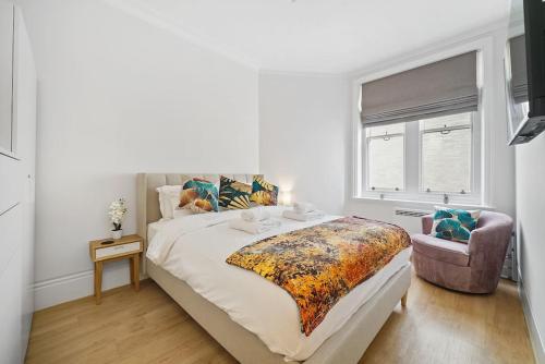 a bedroom with a large bed and a chair at Charming Studio Next to Leicester Sq in London