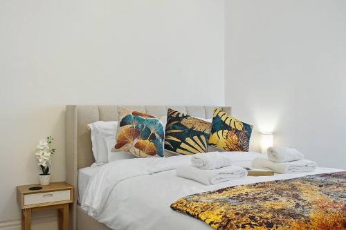 a bed with white sheets and pillows on it at Charming Studio Next to Leicester Sq in London