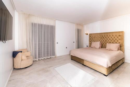 a bedroom with a large bed and a chair at Luxury Duplex 3 Suites -Front Pool-Direct Pool Access in Marrakesh
