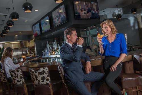 a man and a woman eating at a bar at Hotel Clique Calgary Airport in Calgary