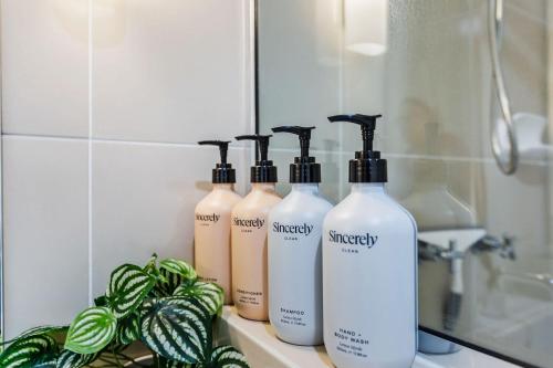 a group of four shampoo bottles sitting on a bathroom counter at La Palma Cairns- Resort 9 Pools & Gym in Westcourt