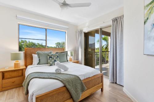 a bedroom with a bed and a large window at La Palma Cairns- Resort 9 Pools & Gym in Westcourt