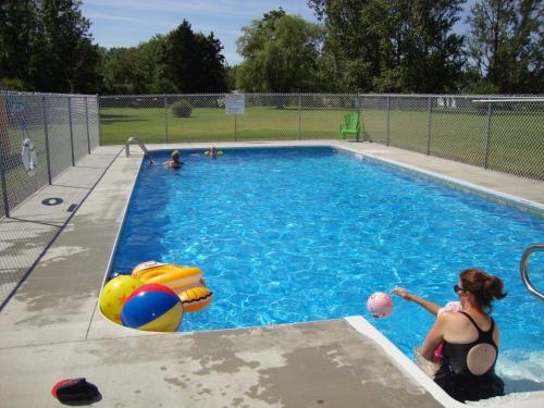 a woman is playing with a ball in a swimming pool at Annapolis Royal Inn in Annapolis Royal