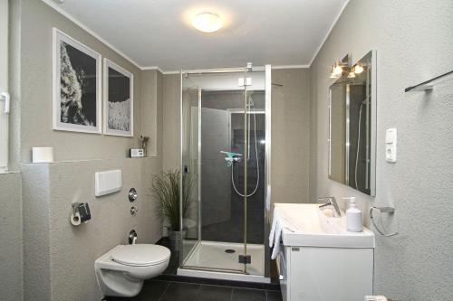 ein Badezimmer mit Dusche, Toilette und Waschbecken in der Unterkunft gratis Nutzung vom AHOI Erlebnisbad und Sauna in Sellin - Kurhaus Nordstrand FeWo 44 in Göhren