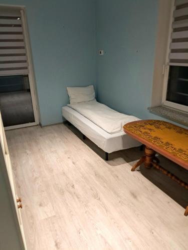 a small room with a bed and a table at VILLA VIP POKOJE pracownicze in Gniezno
