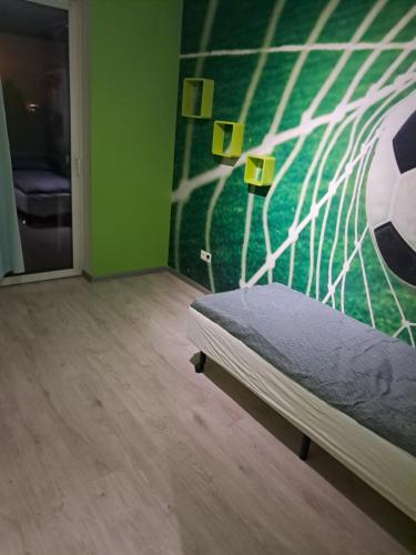 a bedroom with a bed with a soccer mural on the wall at VILLA VIP POKOJE pracownicze in Gniezno