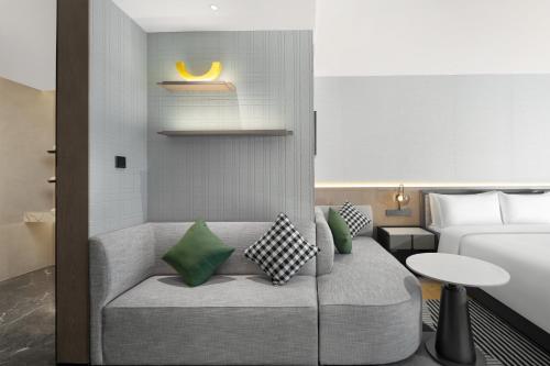 a hotel room with a couch and a bed at Holiday Inn Kunshan East by IHG in Kunshan