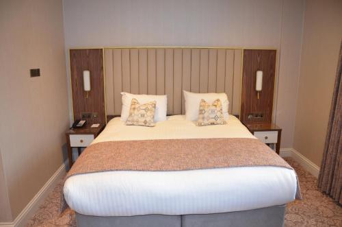 a bedroom with a large bed with two night stands at voco The Clifton Folkestone by IHG in Folkestone