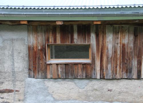 a window on the side of a wooden building at La Grange de Soulalex in Orsières
