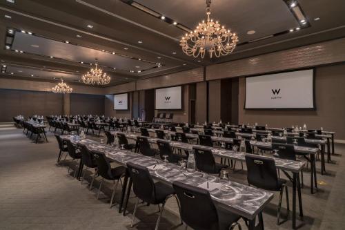 a conference room with tables and chairs and a screen at W Austin in Austin