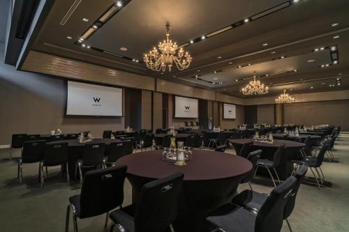 a conference room with tables and chairs and chandeliers at W Austin in Austin