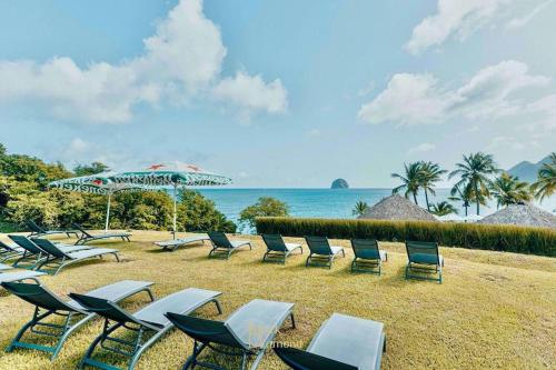 a group of chairs and umbrellas on a beach at 913 Sweety Diamond View in Le Diamant