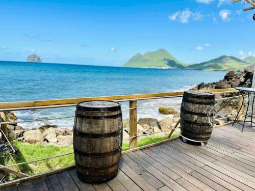 two barrels sitting on a deck looking at the ocean at 913 Sweety Diamond View in Le Diamant