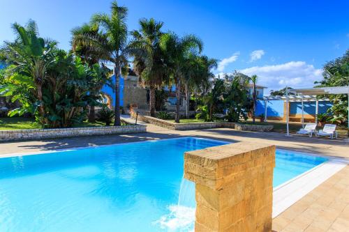 uma grande piscina com palmeiras num quintal em Borgo Marino Plemmirio em Siracusa