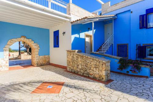 a blue house with a stone wall and stairs at Borgo Marino Plemmirio in Siracusa