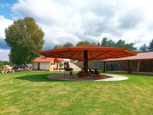 a large red umbrella in the middle of a field at Cabaña para pareja en huasca in Huasca de Ocampo