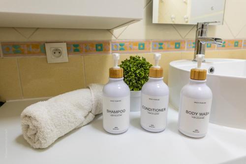 - une salle de bains avec 3 bouteilles de savon et une serviette dans l'établissement Confort à Disneyland, Village nature*Netflix*Wi-Fi, à Bussy-Saint-Georges