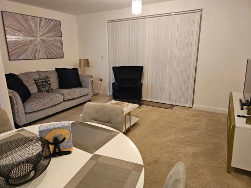 a living room with a couch and a table at The Joyland House in Romsey