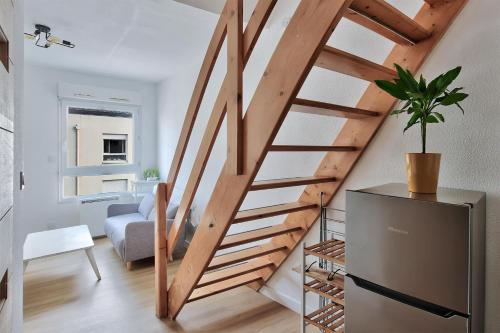- un escalier en bois dans un salon avec une plante en pot dans l'établissement Cocon fifa, à Lyon