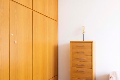 a bedroom with a wooden cabinet and a dresser at DKK1c Ferienwohnung Mole 1 in Niendorf
