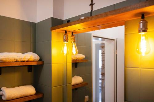 a bathroom with a mirror and lights and towels at DKK1c Ferienwohnung Mole 1 in Niendorf