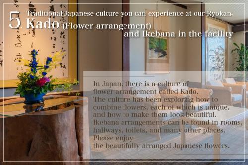 a sign in a room with a table with flowers at Isoaruki no Yuyado Ushiogumo -6 years or older- in Kawazu