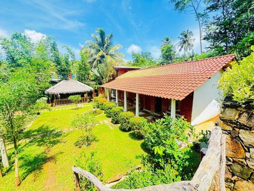 una casa con un prato accanto a un edificio di Sawandara Garden Ayurveda Resort & Spa a Dikwella