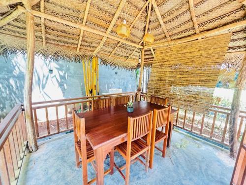 una sala da pranzo con tavolo in legno sul balcone di Sawandara Garden Ayurveda Resort & Spa a Dikwella